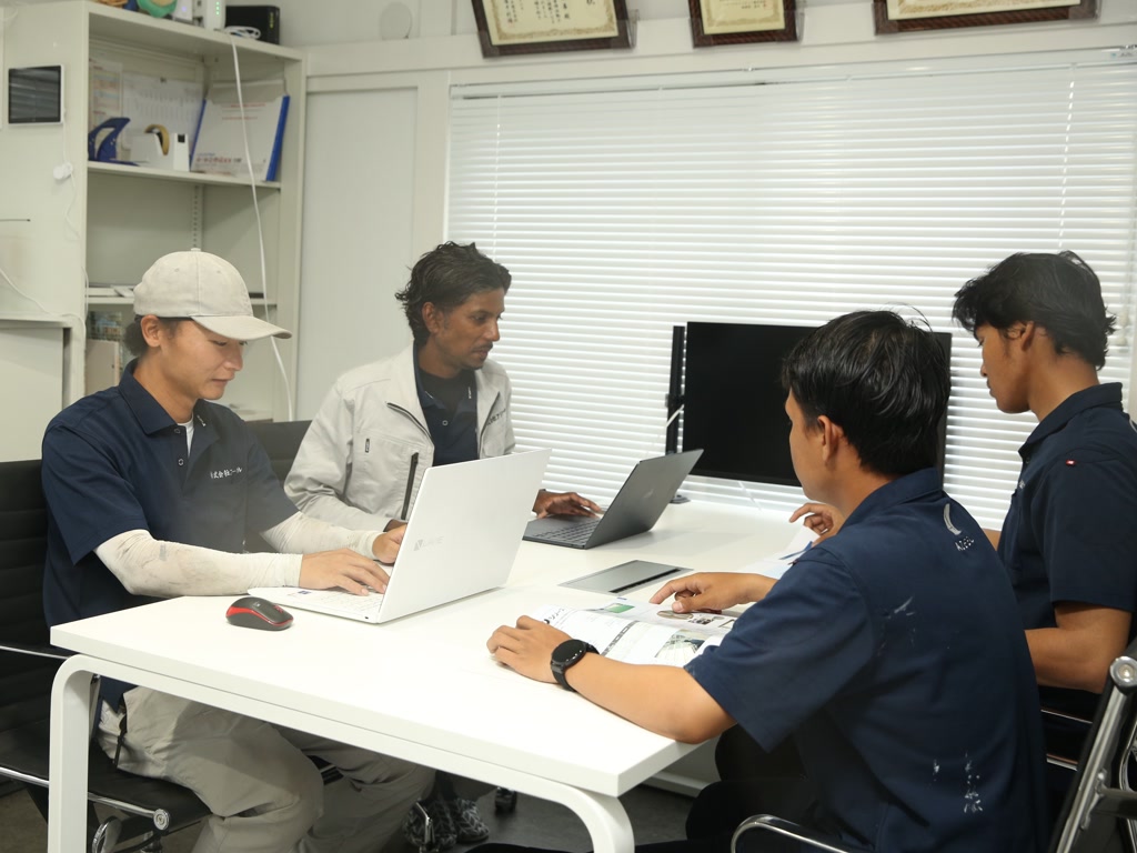 事務所で工事の打ち合わせをするスタッフ